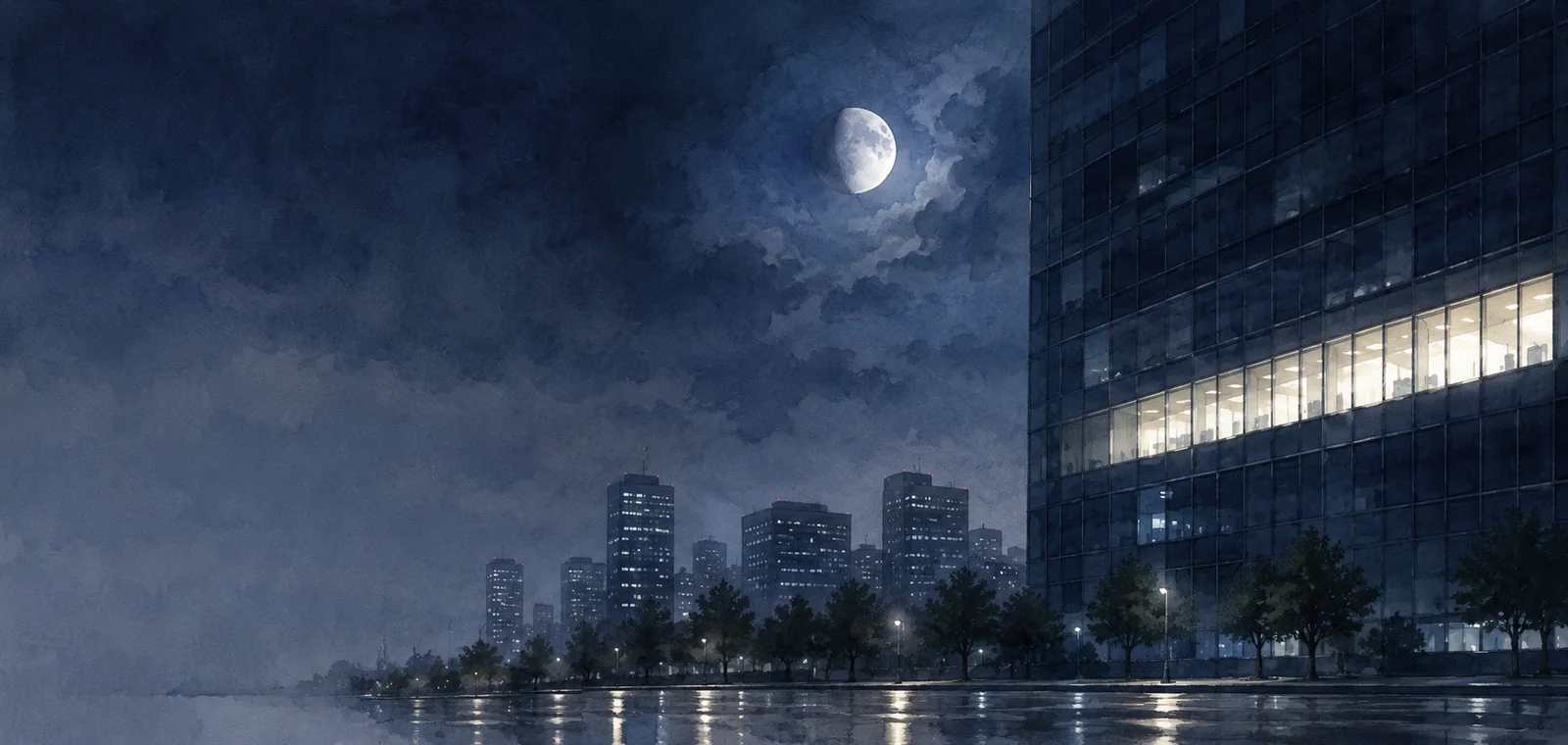 夜のビルの一つの階だけ灯った窓の列